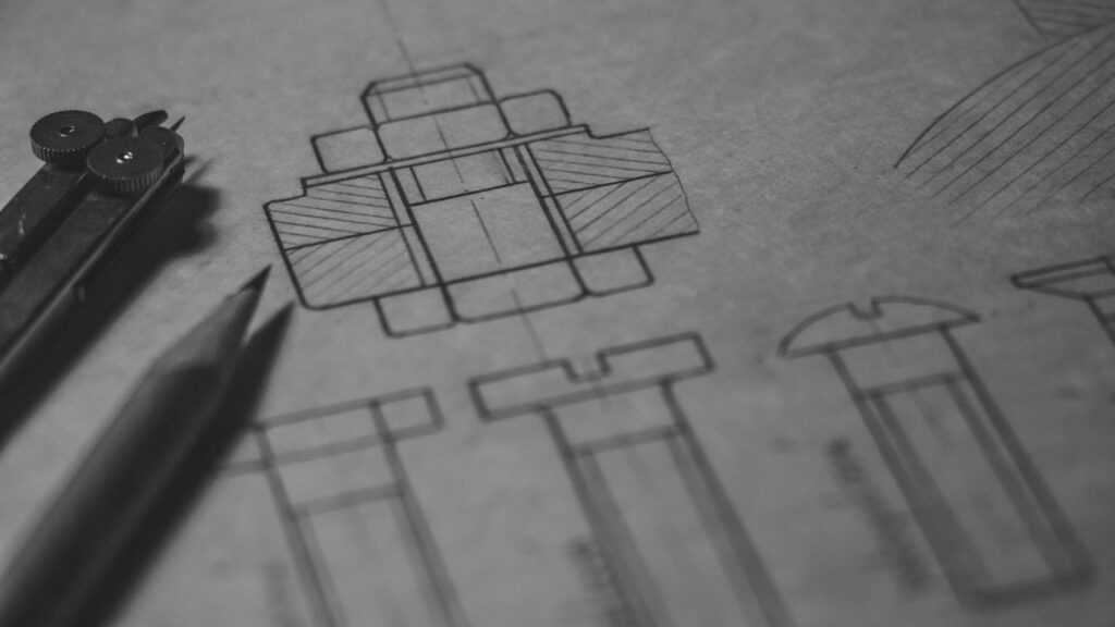 Detailed technical blueprint with pencil and compass illustrating engineering design concepts.